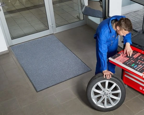 Chłonna mata osuszająca z gumowym spodem w warsztacie mechanika.