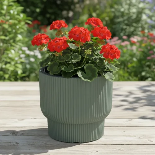 Zielona donica dekoracyjna Milly Prosperplast 30cm stojąca na tarasie