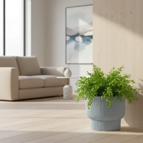 Donica Milly Prosperplast 30 cm szara w nowoczesnym salonie. W donicy rośnie paproć.