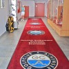 Bardzo długi chodnik wejściowy z logo marki, idealny do kreowania wizerunku firmy na dużych przestrzeniach wystawienniczych.