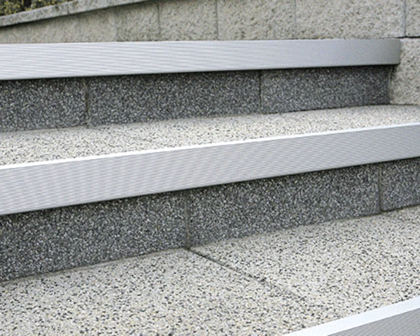 Prezentacja narożnika aluminiowego zamontowanego na krawędzi schodów.