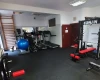 Zastosowanie maty do siłowni w kształcie puzzli na niewielkiej salce fitness.