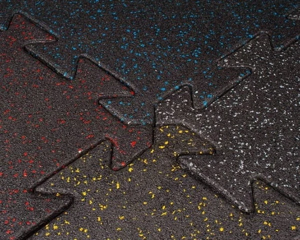 Zbliżenie na fakturę i sposób łączenia maty do siłowni w kształcie puzzli.
