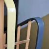 Plastikowa nakładka na poręcz, która stabilnie i sztywno obejmuje stalowy płaskownik balustrady na odnowionej klatce schodowej.