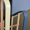 Plastikowa nakładka na poręcz, która stabilnie i sztywno obejmuje stalowy płaskownik balustrady na odnowionej klatce schodowej.