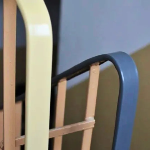 Plastikowa nakładka na poręcz, która stabilnie i sztywno obejmuje stalowy płaskownik balustrady na odnowionej klatce schodowej.