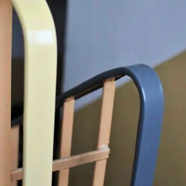 Nakładka na poręcz, która stabilnie i sztywno obejmuje stalowy płaskownik balustrady na odnowionej klatce schodowej.