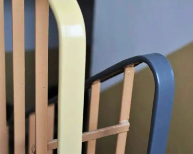 Plastikowa nakładka na poręcz, która stabilnie i sztywno obejmuje stalowy płaskownik balustrady na odnowionej klatce schodowej.