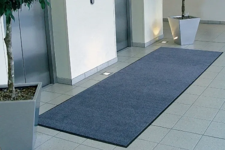 Długa wycieraczka osuszająca Strongmata leżąca przed strefa wind w biurowcu.