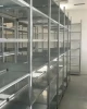 Przemysłowe regały półkowe META CLIP S3 ustawione w długim szeregu za pomocą modułowej rozbudowy ramy bezśrubowej.