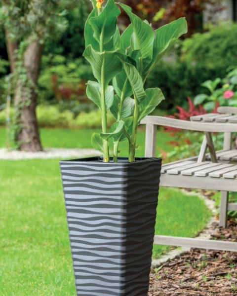 Stylowa donica ogrodowa wyeksponowana na tle zielonej roślinności