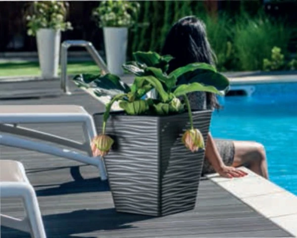 Dekoracyjne donice z rośliną w ogrodowej aranżacji na świeżym powietrzu.