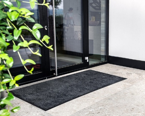 Profesjonalna mata pod drzwi z ekologicznego nylonu ułożona w strefie wejściowej o dużym natężeniu ruchu