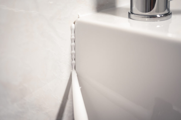 Uszczelnienie zlewu silikonem sanitarnym białym